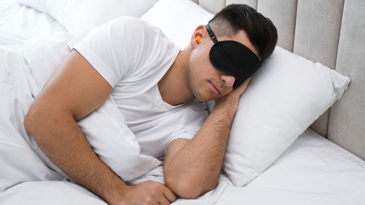 man sleeping with flents ear plugs